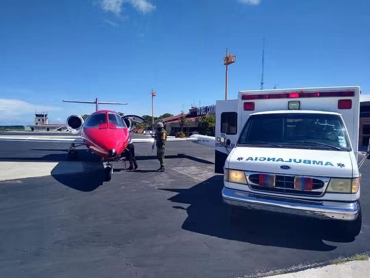 Ambulancia aérea con nariz roja estacionada en la pista junto a una ambulancia terrestre, lista para el traslado de un paciente