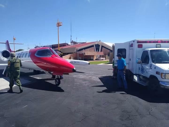 Ambulancia aérea en la plataforma del aeropuerto junto a una ambulancia terrestre y personal de apoyo