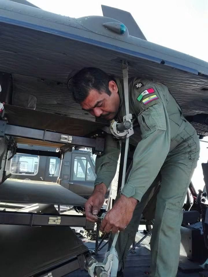 Paramédico de vuelo con uniforme verde asegurando la camilla y el equipo dentro de la aeronave